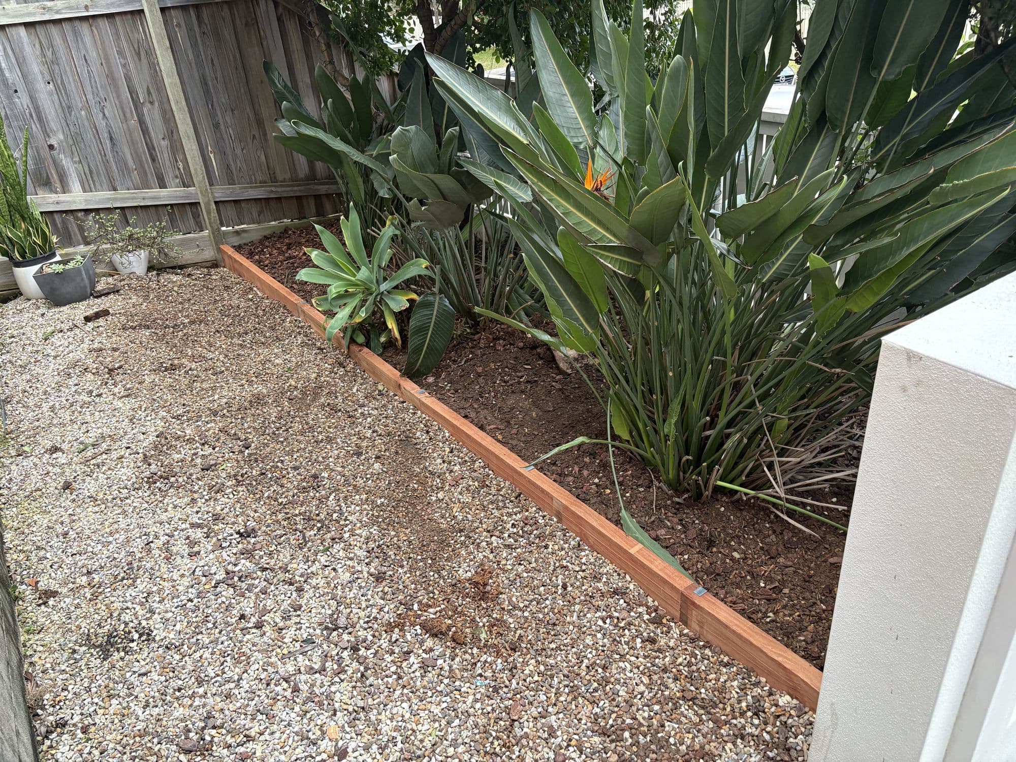 Garden bed with new timber edging against gravel